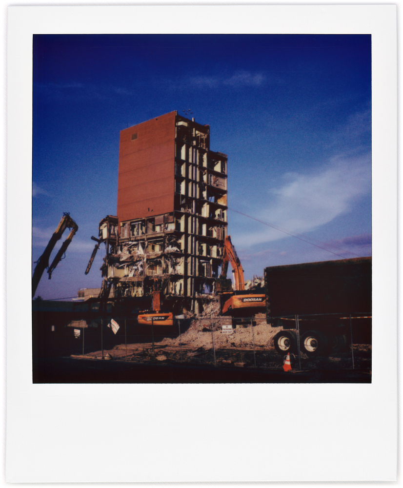 A Polaroid photo of the Saint Joseph Hospital demolition in Fort Wayne, Indiana. Cables connecting the steel frame of the building to construction machinery will be used to try to pull down the building.