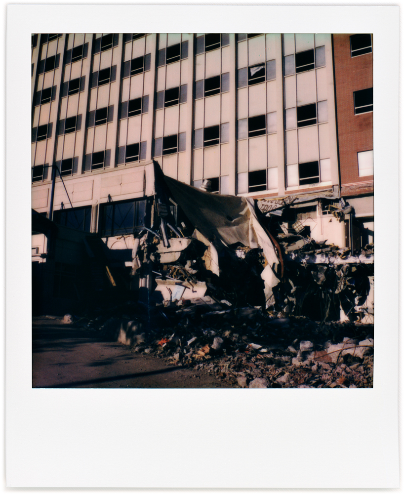 A Polaroid photo of the front of the partially demolished Saint Joseph Hospital building on Broadway in downtown Fort Wayne, Indiana. Only the lower floors have been demolished. 